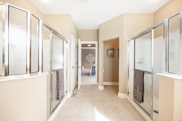 bathroom featuring tile patterned floors, a stall shower, and baseboards