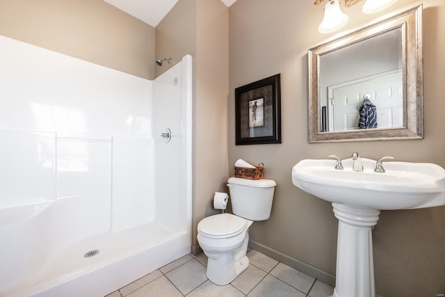 full bathroom featuring tile patterned floors, baseboards, toilet, and walk in shower