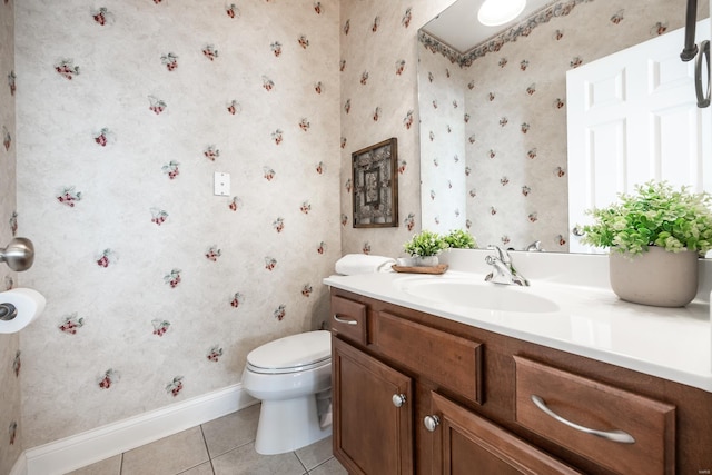 bathroom with tile patterned flooring, wallpapered walls, baseboards, toilet, and vanity