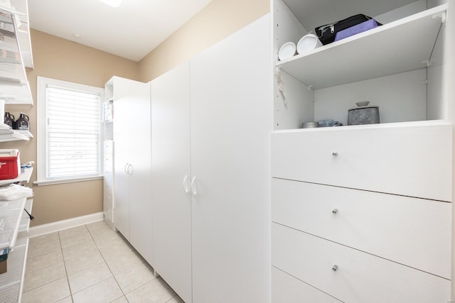 interior space featuring light tile patterned floors and baseboards