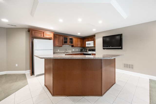 kitchen with visible vents, a kitchen island, recessed lighting, white appliances, and a sink