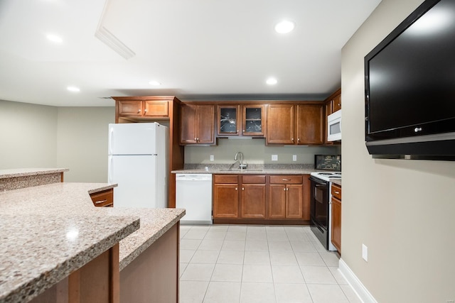 kitchen featuring white appliances, glass insert cabinets, recessed lighting, and a sink