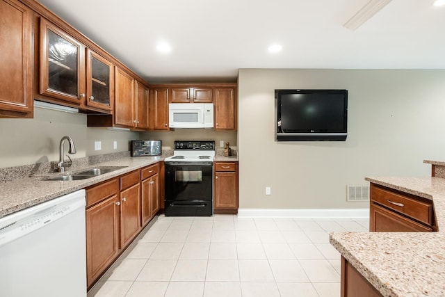 kitchen with visible vents, brown cabinets, white appliances, and a sink