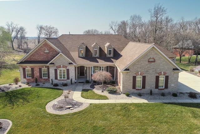 view of front facade featuring a front yard, stone siding, and roof with shingles