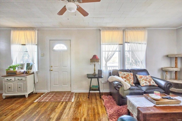 entrance foyer featuring ornamental molding, wood finished floors, a ceiling fan, and baseboards