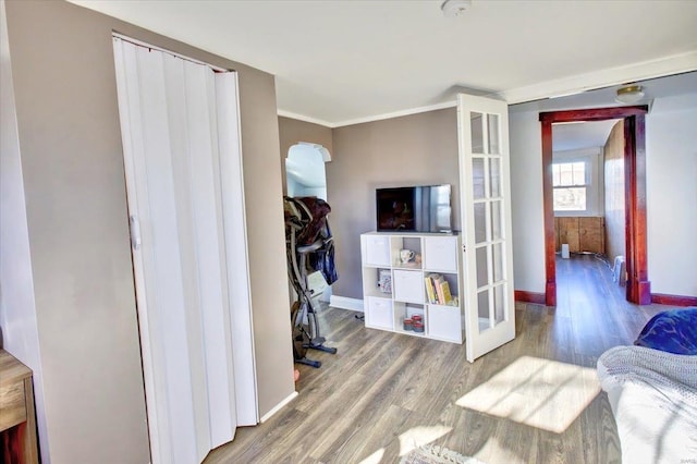 bedroom with ornamental molding, french doors, baseboards, and wood finished floors