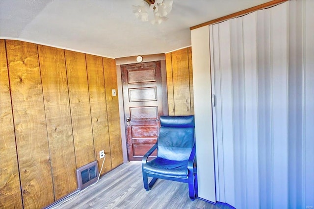 interior space featuring visible vents, wooden walls, and wood finished floors