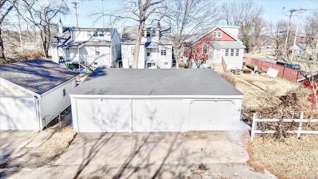 detached garage featuring a residential view and fence