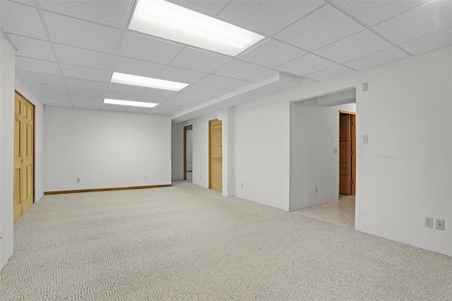 carpeted spare room featuring a paneled ceiling