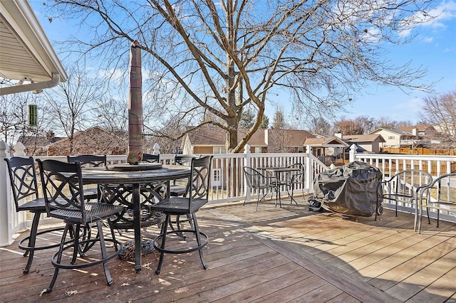 wooden deck with a grill, a residential view, and outdoor dining area