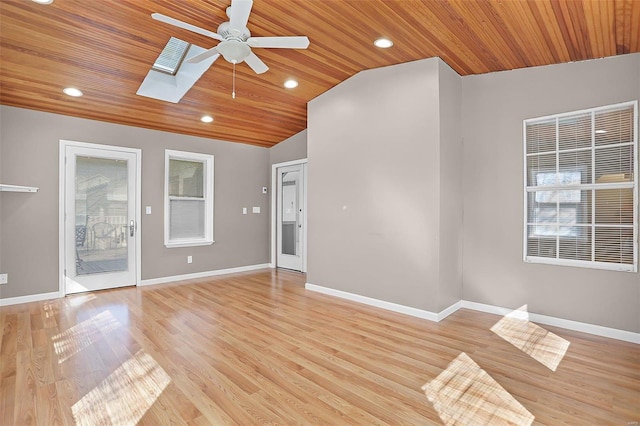 empty room featuring light wood finished floors, recessed lighting, lofted ceiling with skylight, wood ceiling, and baseboards