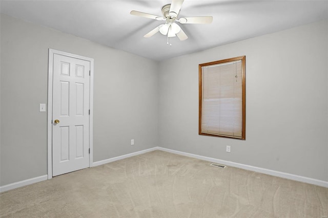 empty room featuring visible vents, ceiling fan, light carpet, and baseboards