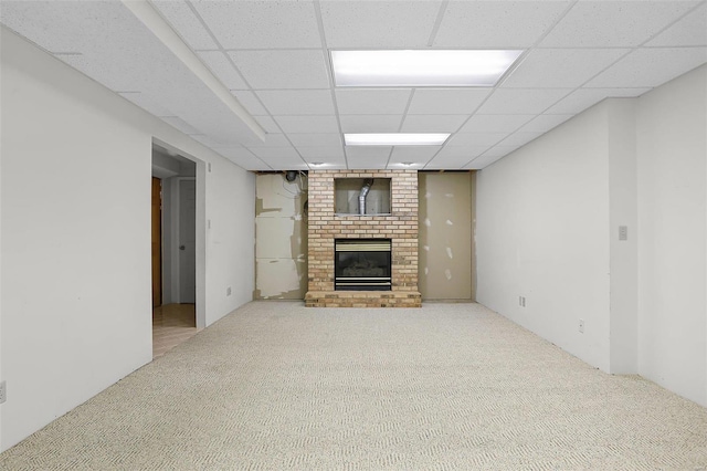 unfurnished living room with carpet floors, a drop ceiling, and a fireplace