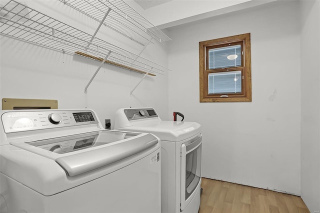 laundry room featuring laundry area, light wood-style flooring, and washing machine and clothes dryer