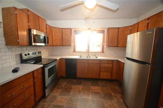 kitchen with stainless steel appliances, a sink, light countertops, brown cabinets, and decorative backsplash