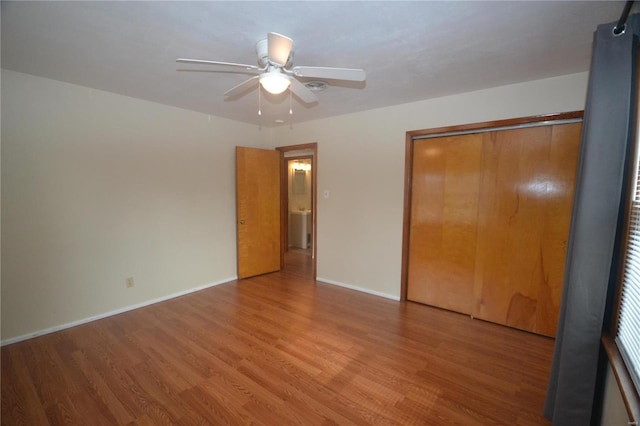 unfurnished bedroom with a ceiling fan, a closet, baseboards, and wood finished floors