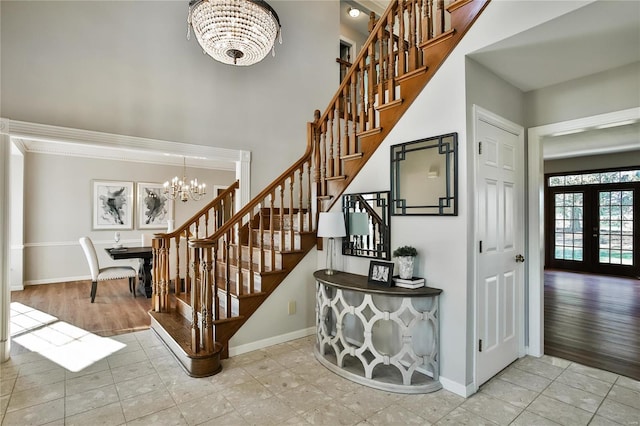 stairs featuring a chandelier, french doors, crown molding, and baseboards