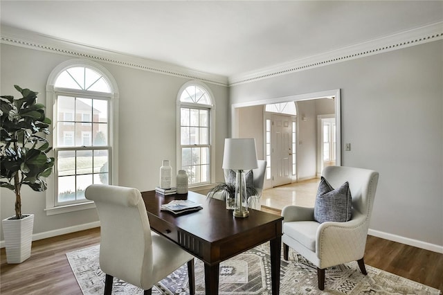 office space featuring ornamental molding, baseboards, and wood finished floors