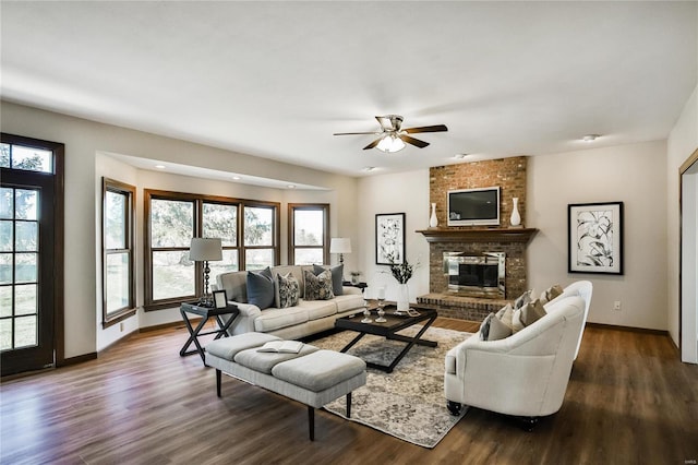 living room with a healthy amount of sunlight, a fireplace, dark wood finished floors, and baseboards