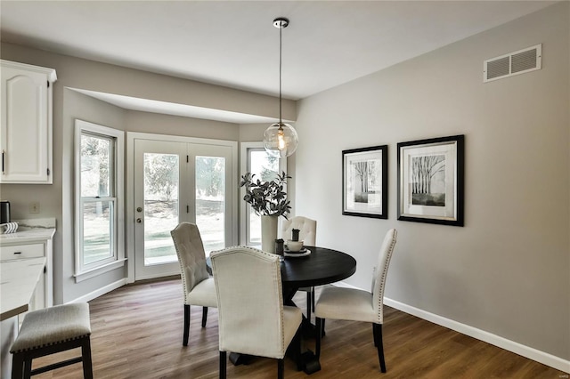 dining area featuring visible vents, dark wood finished floors, and baseboards