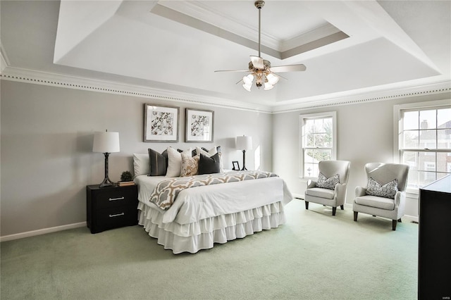 bedroom with ornamental molding, carpet, and a tray ceiling