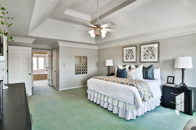 carpeted bedroom featuring ornamental molding, a tray ceiling, a ceiling fan, and baseboards