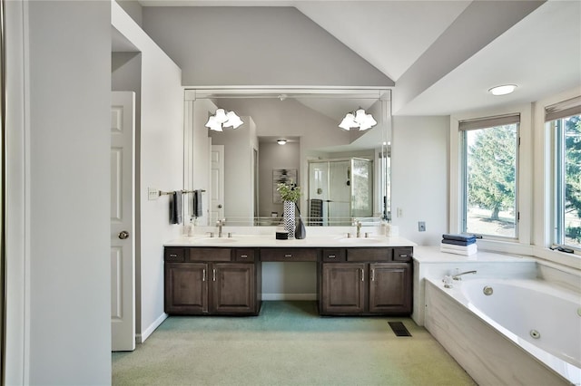 bathroom with lofted ceiling, a sink, a shower stall, and a tub with jets