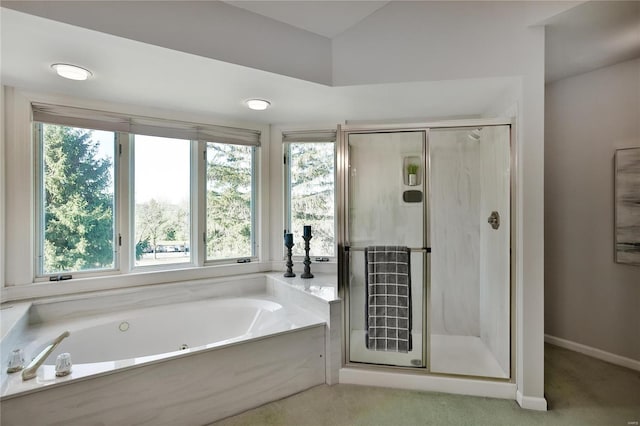 full bathroom featuring a stall shower, baseboards, and a garden tub