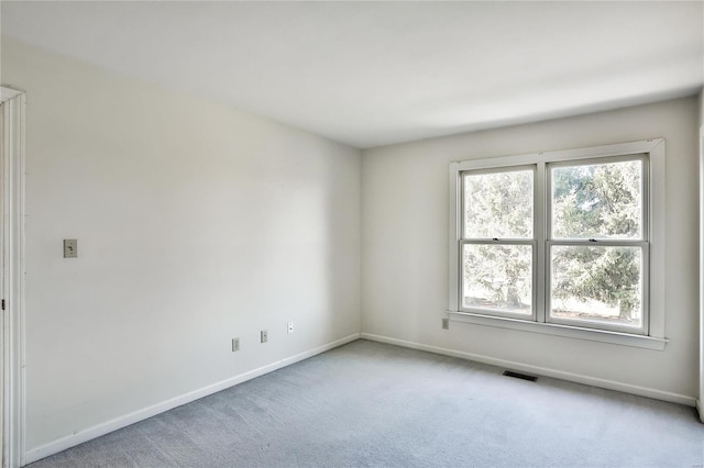 unfurnished room featuring light colored carpet, visible vents, and baseboards