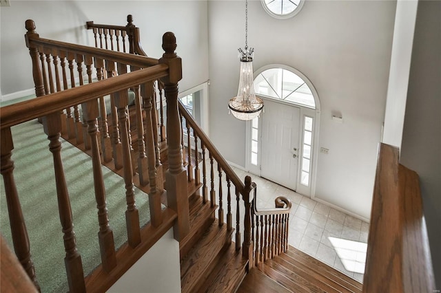 entrance foyer featuring plenty of natural light, wood finished floors, a towering ceiling, and baseboards