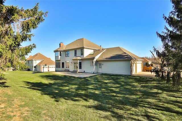 rear view of house featuring a garage, a patio, a lawn, and a chimney