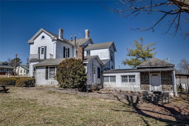 view of front of home with a front yard and a chimney