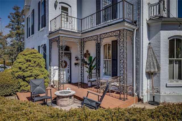 property entrance featuring a balcony and brick siding