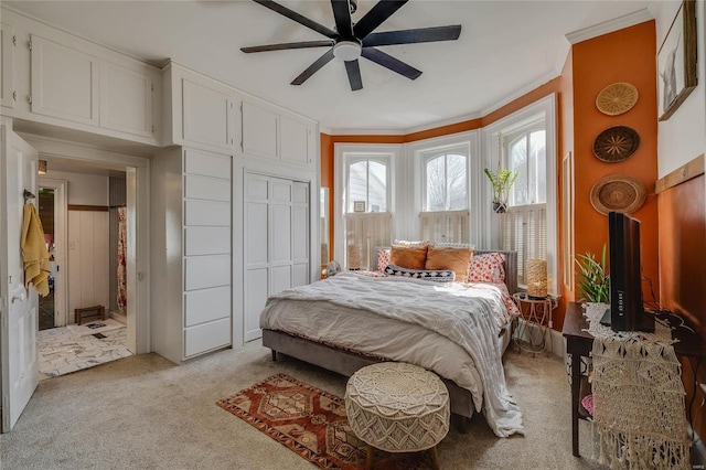 bedroom with ceiling fan, light carpet, and ornamental molding