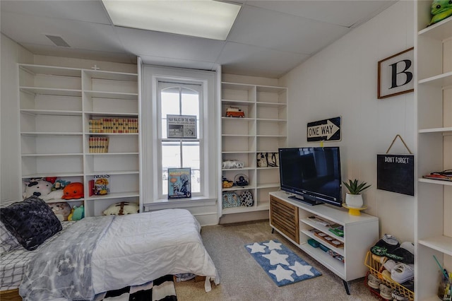 carpeted bedroom with a paneled ceiling