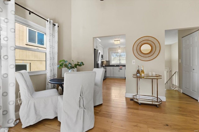 dining space with light wood-style flooring and baseboards