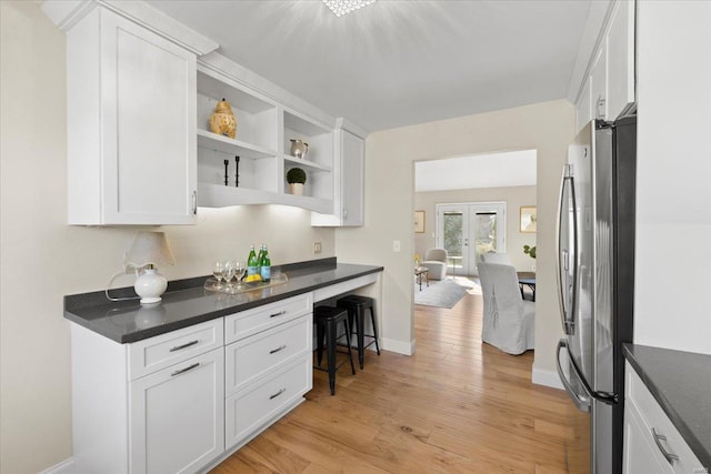 kitchen with light wood finished floors, french doors, white cabinetry, and freestanding refrigerator