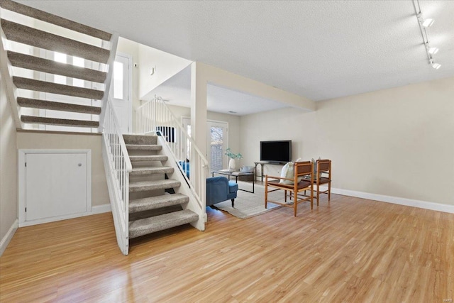 interior space with light wood finished floors, stairway, and baseboards