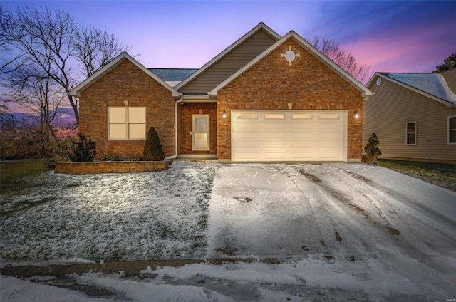 view of front of home featuring driveway, brick siding, and an attached garage