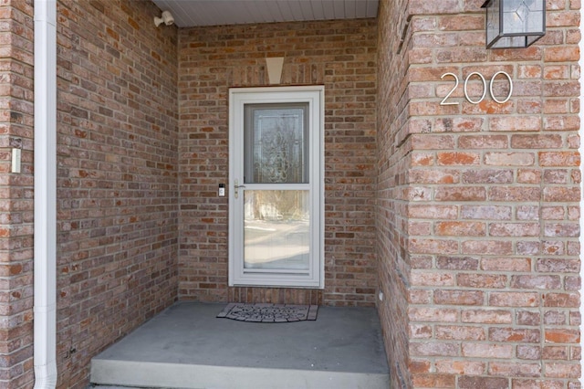 doorway to property featuring brick siding