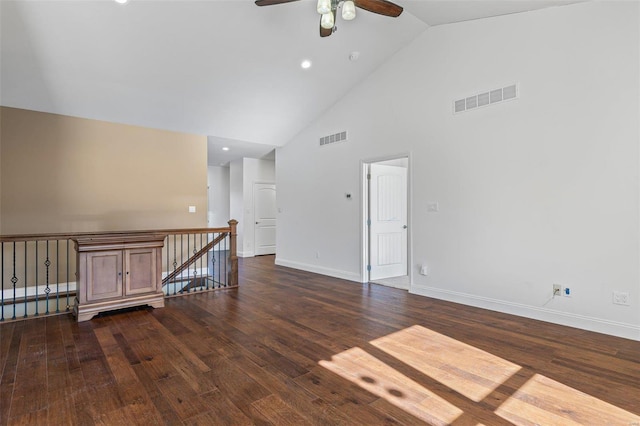 unfurnished room with dark wood-type flooring, visible vents, high vaulted ceiling, and baseboards