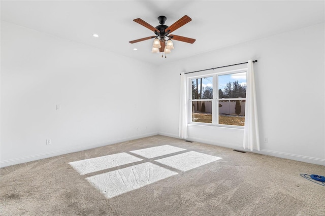 empty room featuring a ceiling fan, recessed lighting, light carpet, and baseboards