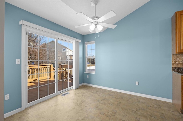 unfurnished dining area featuring ceiling fan, visible vents, and baseboards