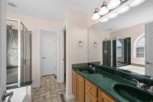 bathroom with double vanity, a shower stall, and a sink