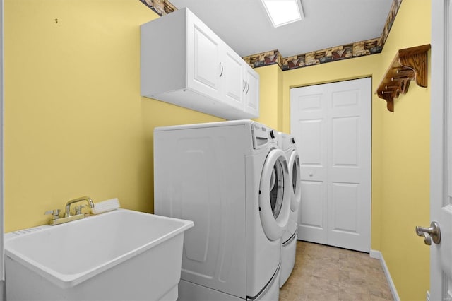 clothes washing area with cabinet space, baseboards, a sink, and independent washer and dryer