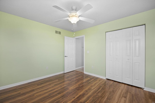 unfurnished bedroom featuring a closet, wood finished floors, visible vents, and baseboards