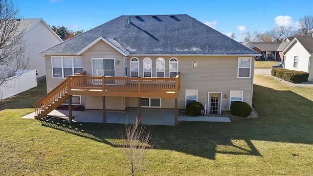 back of house with a yard, roof with shingles, a patio area, and a wooden deck