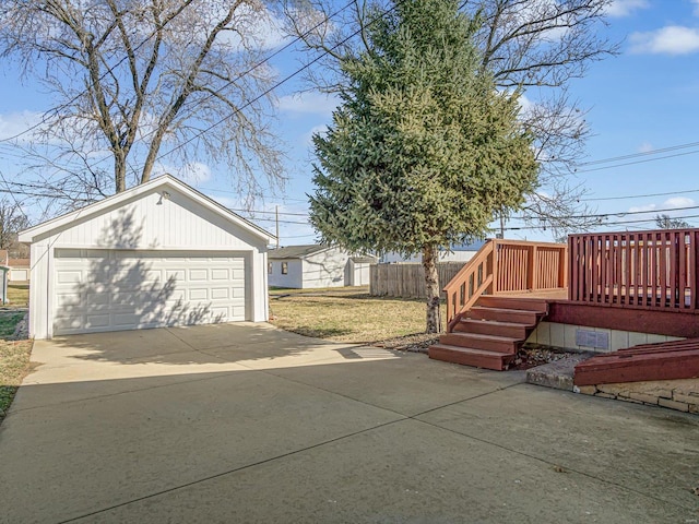 view of yard featuring a detached garage, a wooden deck, and an outdoor structure