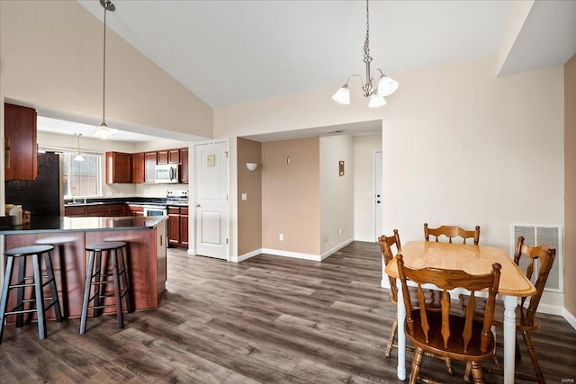 dining area featuring dark wood-style floors, visible vents, a chandelier, and baseboards