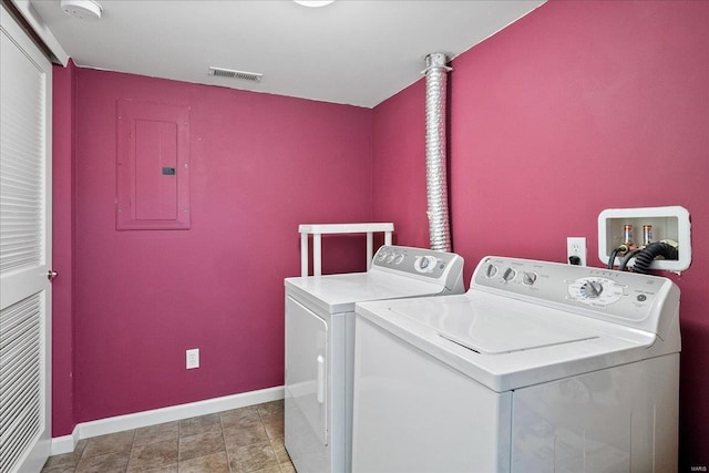 clothes washing area with washing machine and clothes dryer, visible vents, baseboards, electric panel, and laundry area